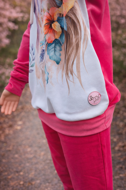 Stylowa bluza dziewczęca z wysokiej jakości dresówki z nadrukiem konia w kwiatach. Model z różowymi rękawami i dopasowanym ściągaczem zapewnia wygodę i modny wygląd na co dzień.